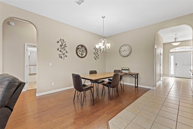 dining room featuring a notable chandelier and light hardwood / wood-style flooring