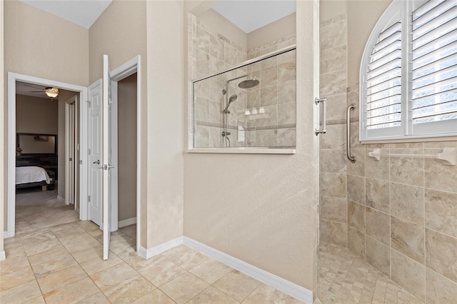 bathroom with a tile shower, tile patterned flooring, and ceiling fan