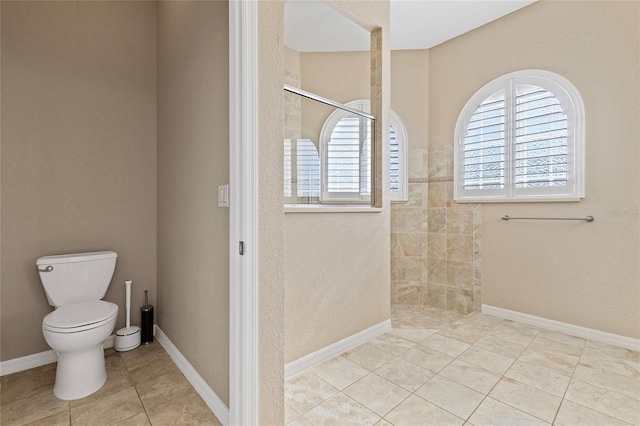 bathroom featuring tiled shower, tile patterned floors, and toilet