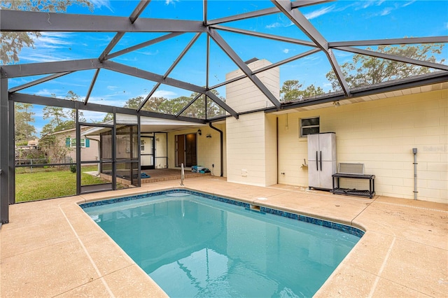 view of pool featuring glass enclosure and a patio