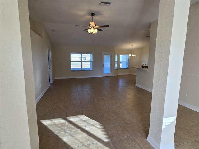 tiled spare room featuring ceiling fan with notable chandelier and vaulted ceiling