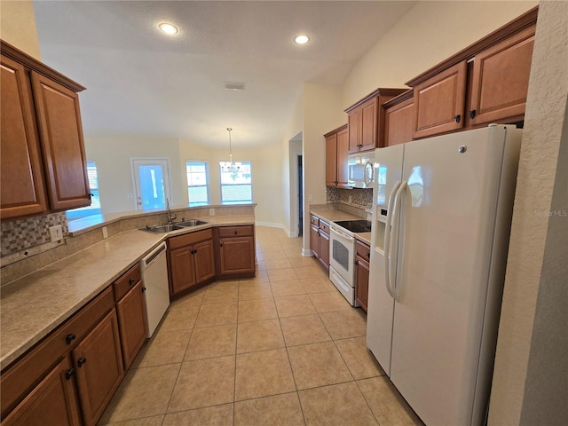 kitchen with decorative backsplash, white appliances, vaulted ceiling, sink, and decorative light fixtures