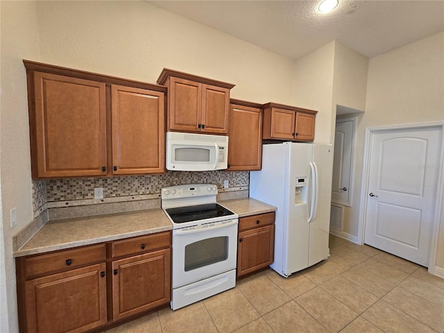 kitchen with a textured ceiling, decorative backsplash, light tile patterned flooring, and white appliances