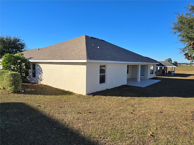 back of house featuring a lawn and a patio