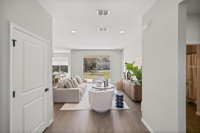 living room featuring a textured ceiling and dark hardwood / wood-style floors