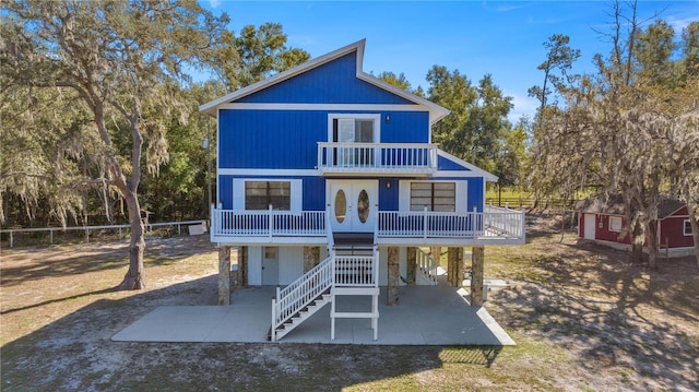 back of property with a balcony, a patio, and french doors