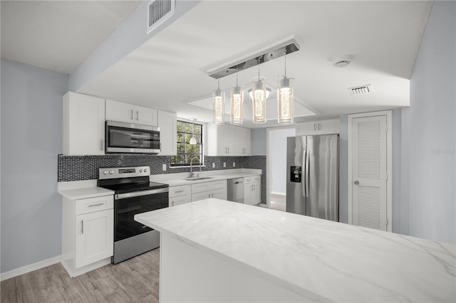 kitchen featuring sink, white cabinets, light hardwood / wood-style flooring, and appliances with stainless steel finishes