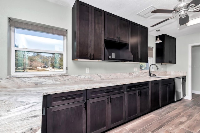 kitchen with dishwasher, sink, dark brown cabinetry, pendant lighting, and ceiling fan