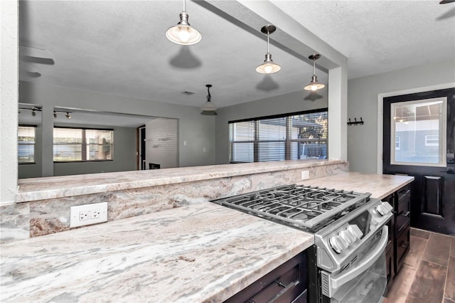 kitchen with gas range, a textured ceiling, pendant lighting, and ceiling fan