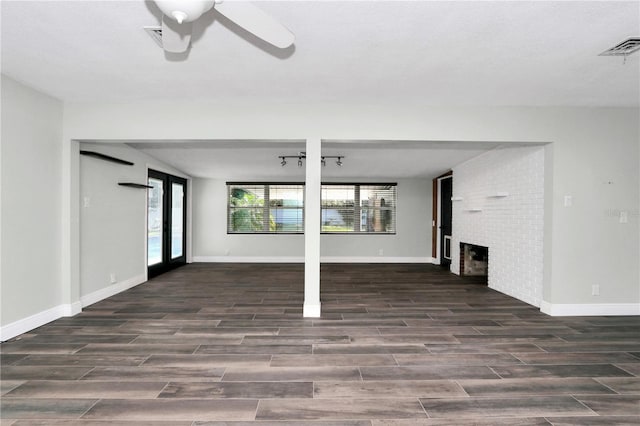 unfurnished living room featuring ceiling fan, french doors, and a brick fireplace