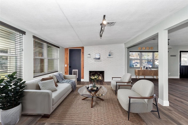 living room featuring a textured ceiling, a fireplace, and hardwood / wood-style floors