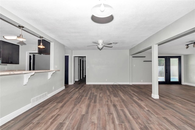 unfurnished living room with ceiling fan, french doors, and a textured ceiling