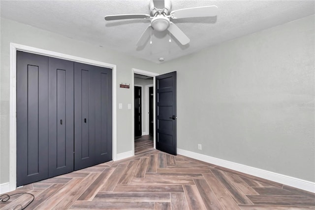 unfurnished bedroom featuring a closet, ceiling fan, parquet floors, and a textured ceiling