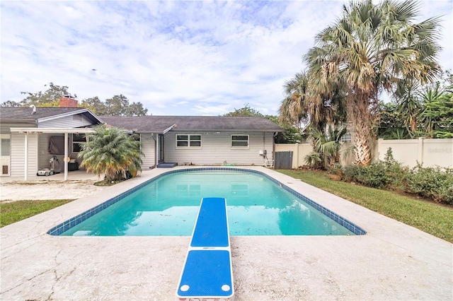 view of pool featuring a diving board and a patio