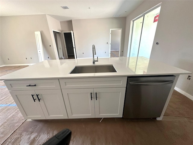 kitchen with dishwasher, light countertops, a sink, and a kitchen island with sink