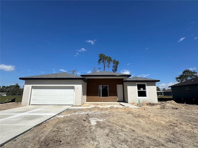 view of front of house featuring an attached garage, driveway, and stucco siding