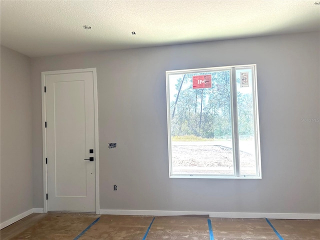 entrance foyer with a textured ceiling and baseboards