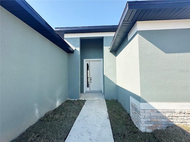 view of exterior entry with stucco siding