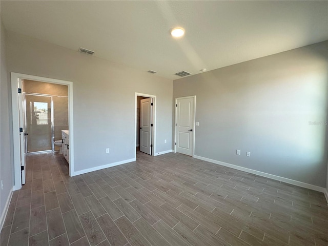 unfurnished bedroom with dark wood finished floors, visible vents, and baseboards