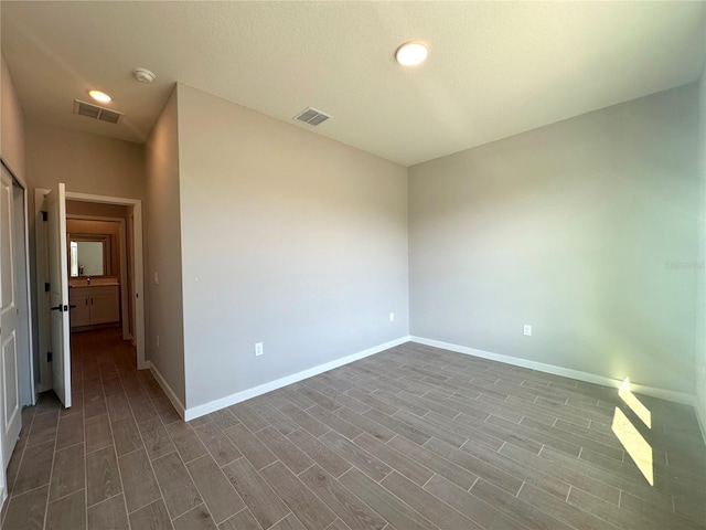 spare room with dark wood-style floors, baseboards, and visible vents