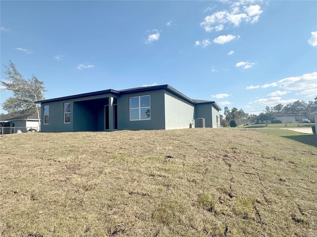 back of house with a yard and stucco siding