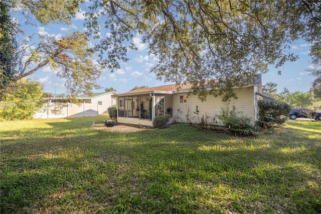 back of property featuring a yard and a sunroom