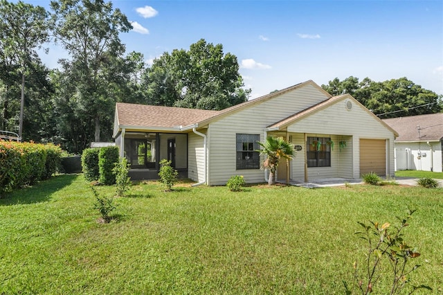 single story home with a sunroom, a front yard, and a garage