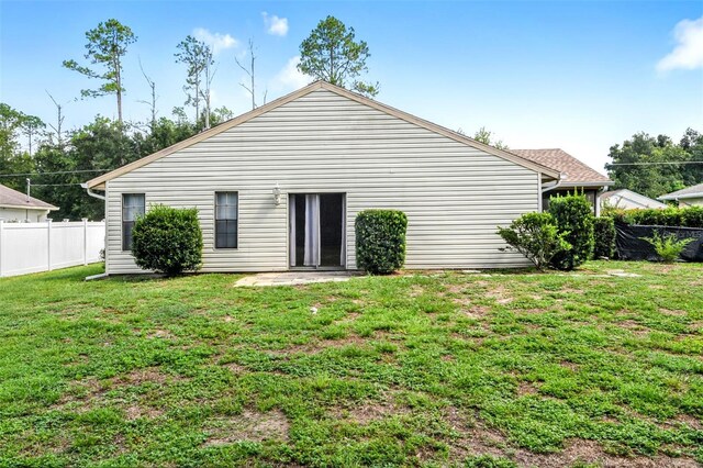 rear view of house featuring a lawn