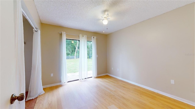 empty room with light hardwood / wood-style floors and a textured ceiling