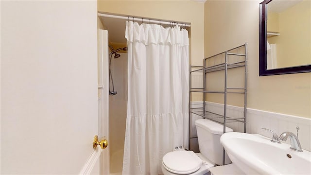 bathroom with curtained shower, toilet, and sink