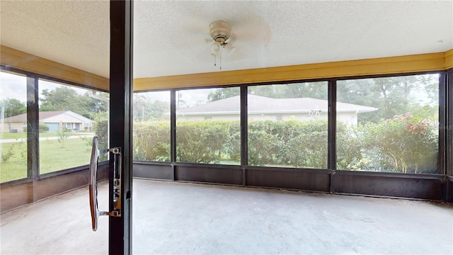 unfurnished sunroom with ceiling fan