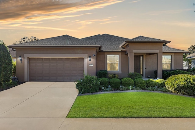 prairie-style home featuring a garage and a yard