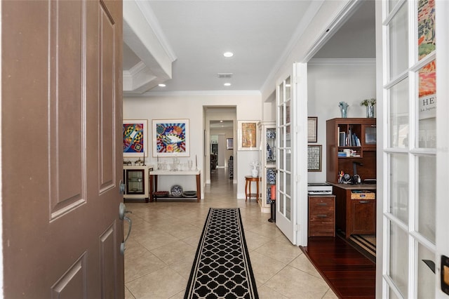 hallway featuring light tile patterned floors, crown molding, and french doors