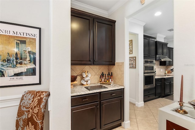 kitchen with backsplash, ornamental molding, dark brown cabinetry, stainless steel appliances, and light tile patterned floors