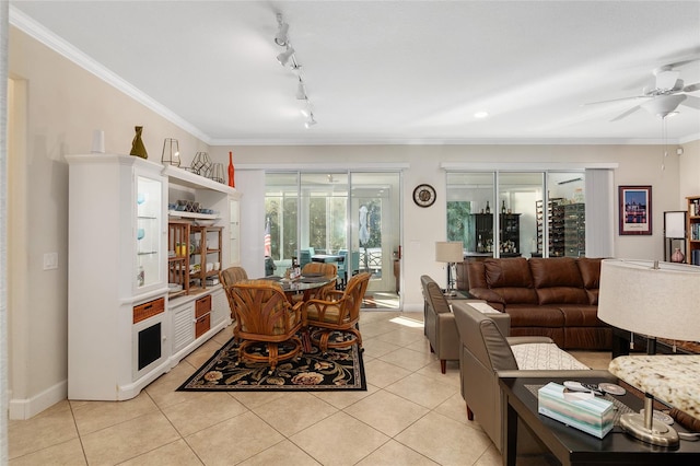 living room with light tile patterned floors, rail lighting, ceiling fan, and ornamental molding