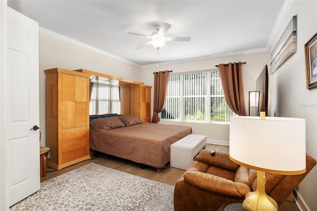 bedroom featuring multiple windows, ceiling fan, crown molding, and light hardwood / wood-style floors