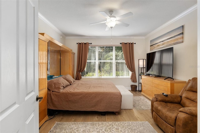 bedroom featuring ceiling fan, crown molding, and light hardwood / wood-style flooring