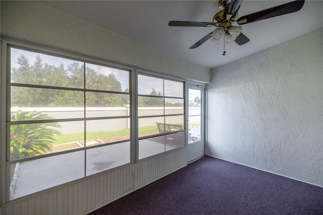 unfurnished sunroom featuring ceiling fan