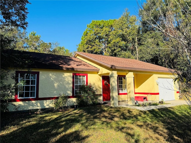 ranch-style home with a garage and a front lawn