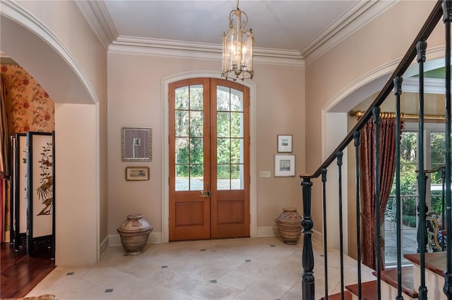 entrance foyer featuring french doors, ornamental molding, and a notable chandelier