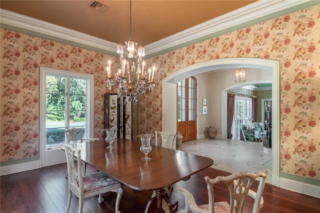 dining space with dark hardwood / wood-style flooring, ornamental molding, and a chandelier