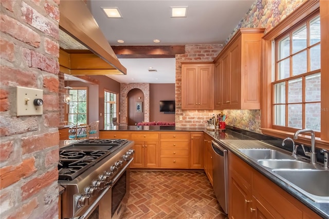 kitchen with backsplash, exhaust hood, sink, and appliances with stainless steel finishes