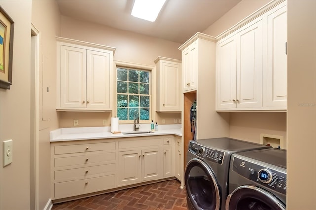 clothes washing area with cabinets, separate washer and dryer, and sink