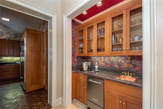 bar featuring decorative backsplash, stainless steel appliances, dark stone counters, and sink