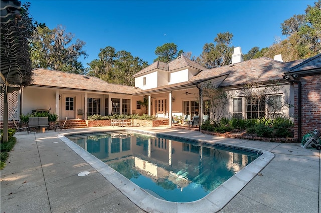 exterior space featuring a swimming pool with hot tub and a patio area