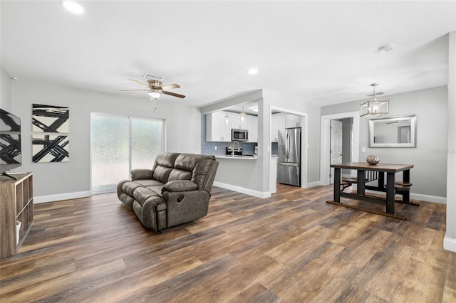 living room featuring ceiling fan and dark wood-type flooring