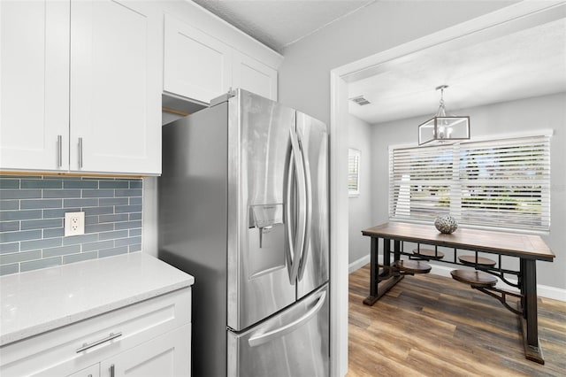 kitchen with dark hardwood / wood-style flooring, backsplash, pendant lighting, white cabinets, and stainless steel fridge with ice dispenser