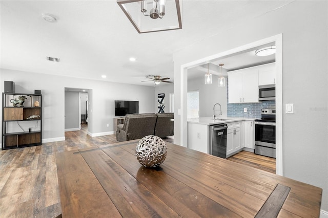 dining area featuring light wood-type flooring, ceiling fan, and sink