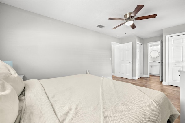 bedroom with ensuite bath, ceiling fan, and light wood-type flooring