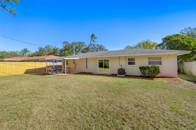 rear view of property featuring cooling unit, a patio area, and a yard